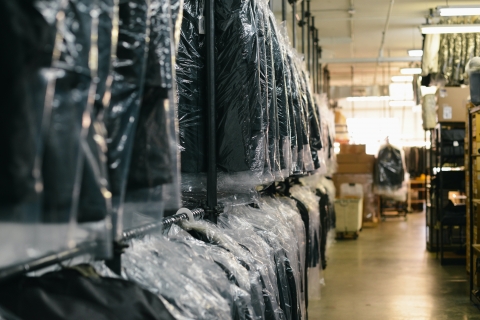 dry cleaning hangs from racks in a dry cleaning shop